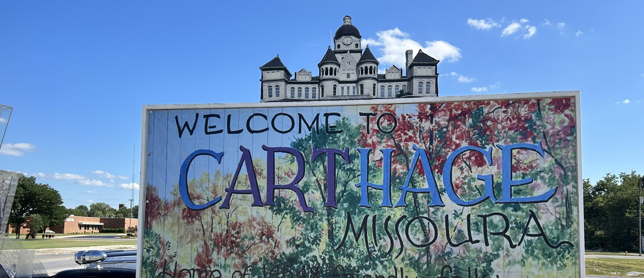 Welcome to Carthage Missoura sign with the Jasper County courthouse in the background.